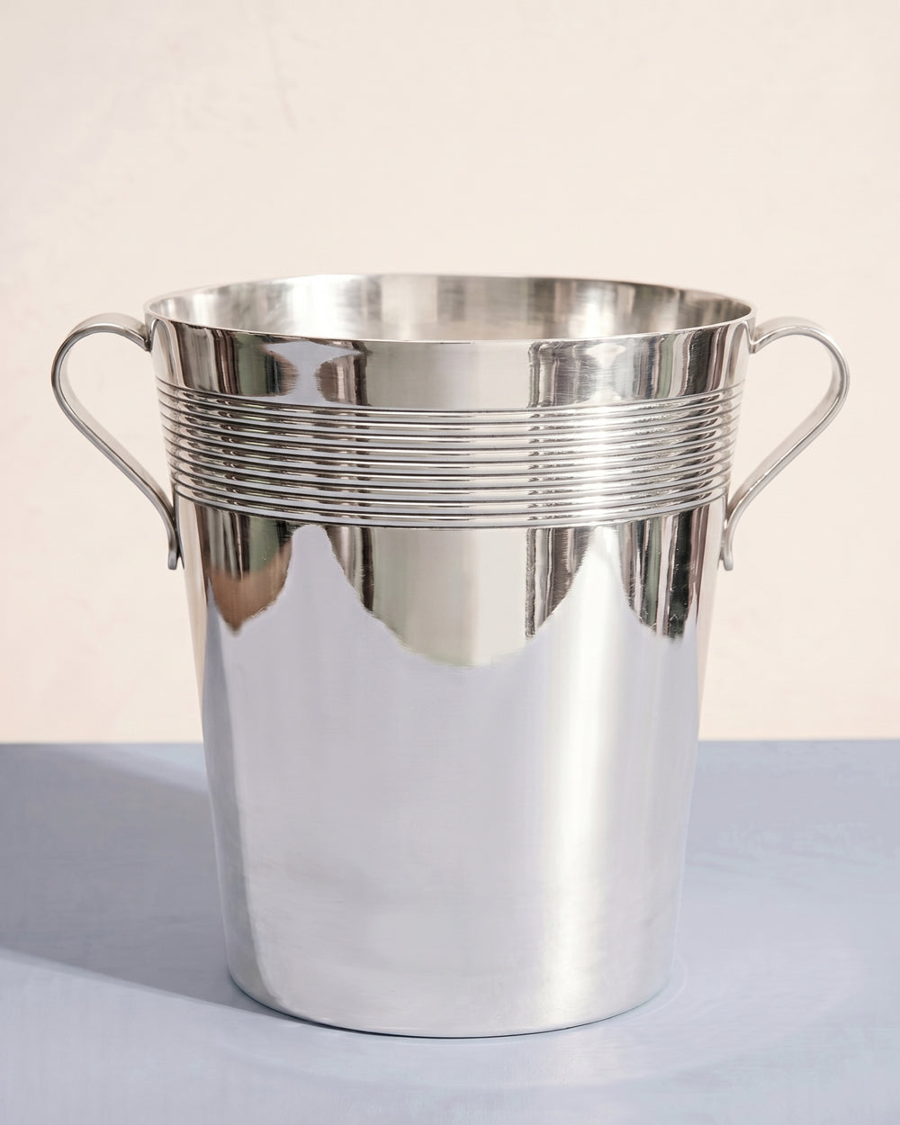 Vintage Art Deco style silver plated ice bucket or champagne cooler on a light blue background, available at Wildschut Antiques.