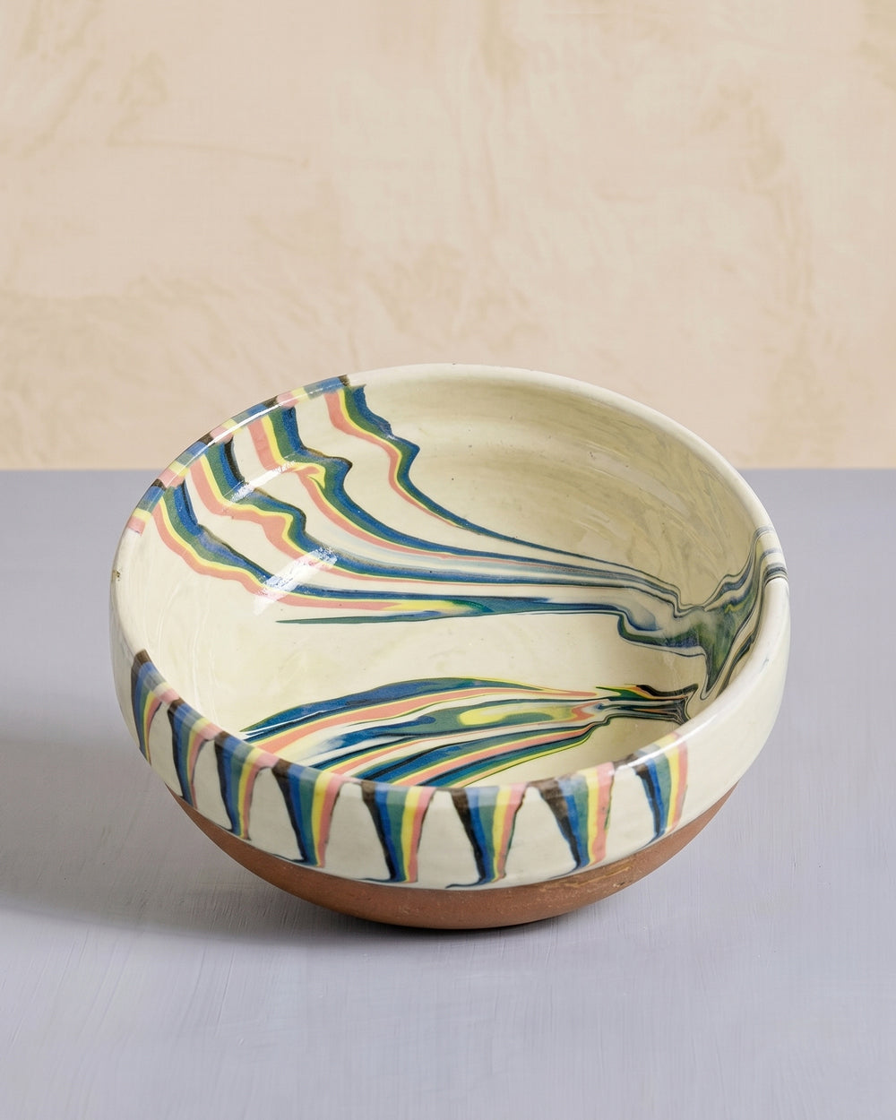 Vintage ceramic bowl with colorful marbled design on a neutral background, available at Wildschut Antiques.