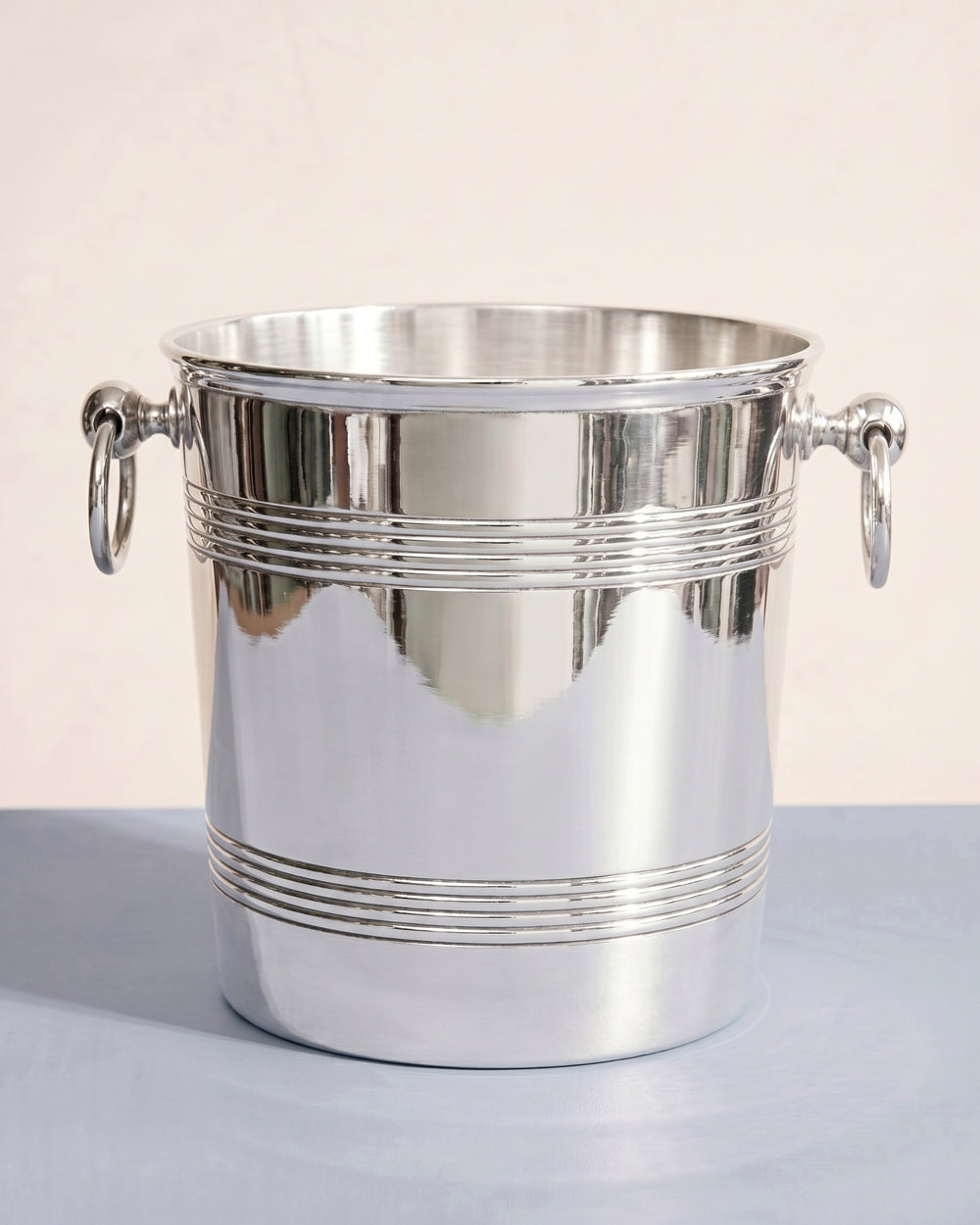 Vintage silver plated ice bucket or champagne cooler by Ercuis on a light blue background, available at Wildschut Antiques.