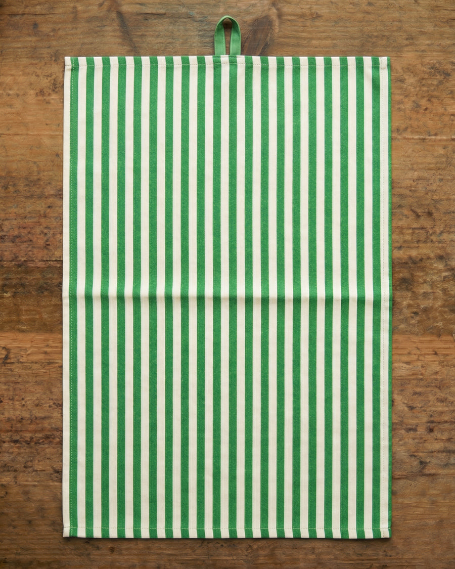 Green and white striped towel on a wooden surface, available via Wildschut Antiques.