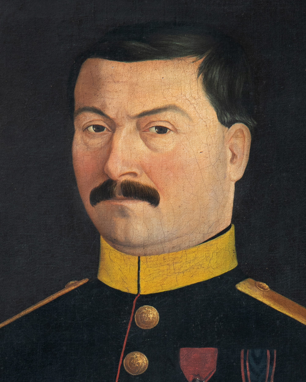 A painted portrait of a man with dark hair and a mustache, wearing a dark military-style uniform with a bright yellow collar and gold buttons, against a dark background. Close-up of an antique portrait of a French Military Man, ca, 1850 - 1870, available via Wildschut Antiques.